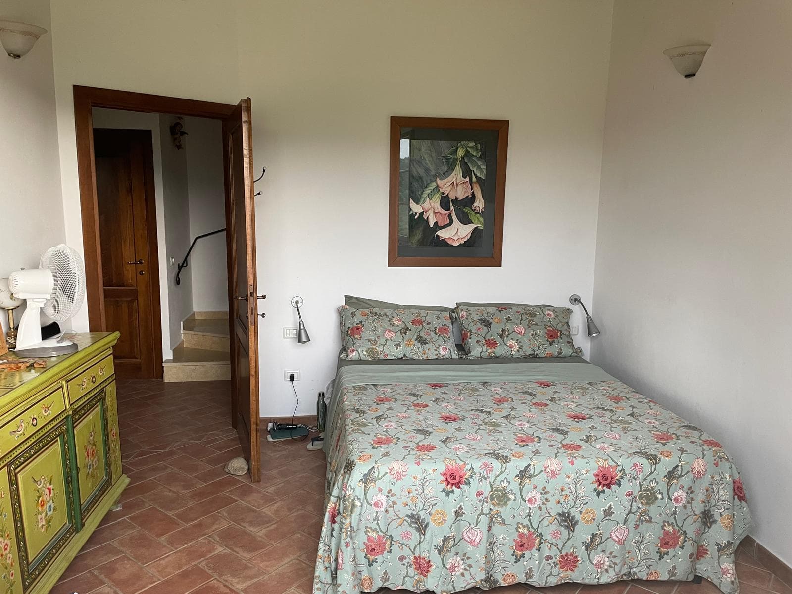 Double bedroom with floral bedding and a painted dresser