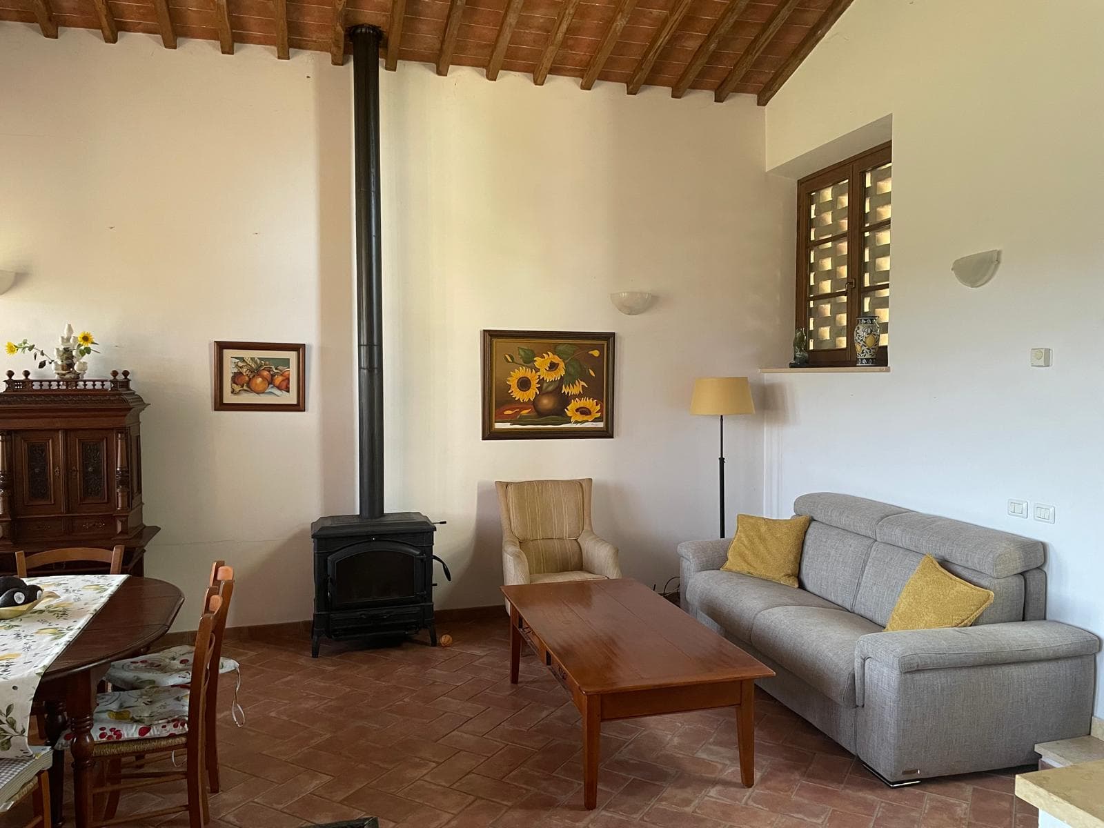 The open-plan living room at Casa Brunelli with stone walls and warm light
